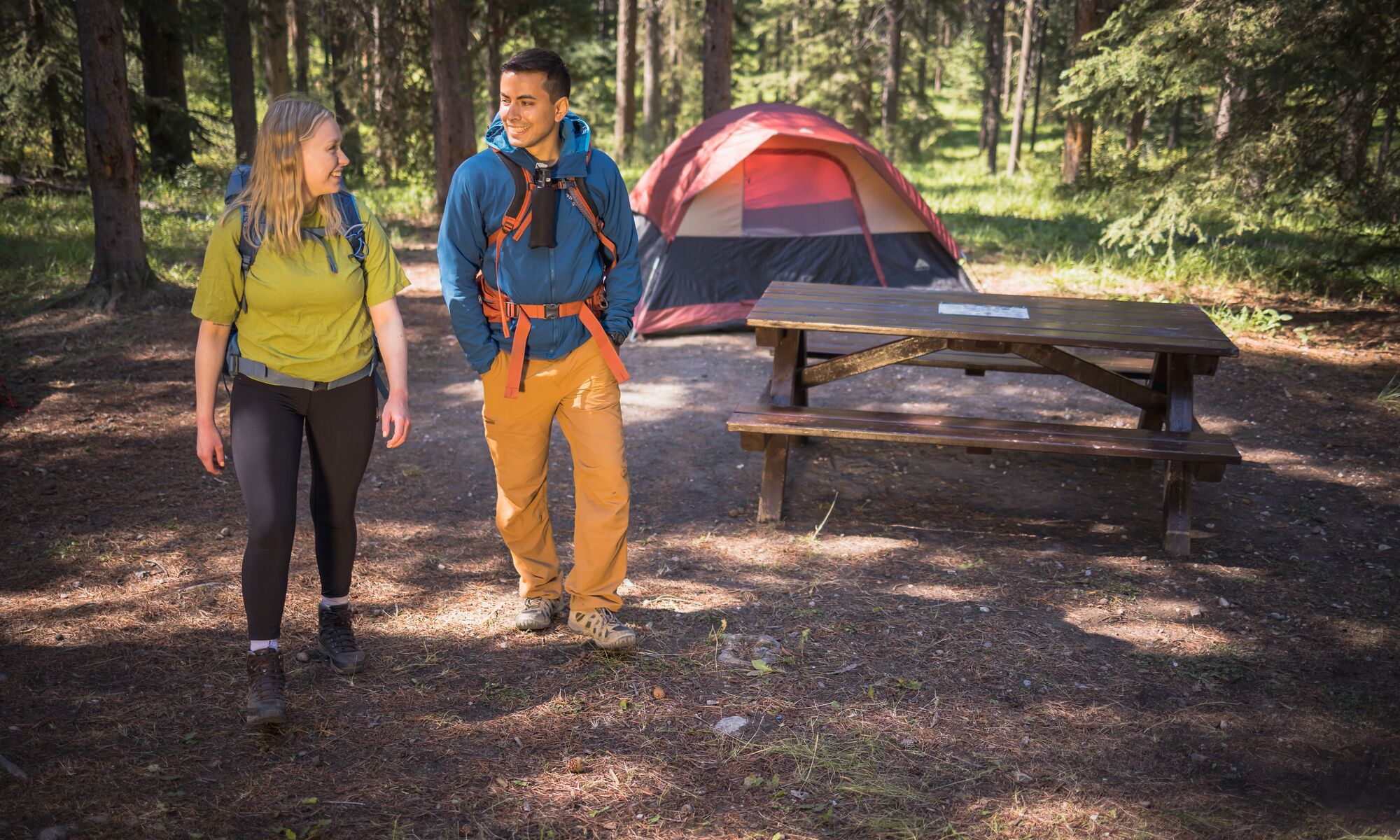 Two people walking away from their campsite in Banff National Park