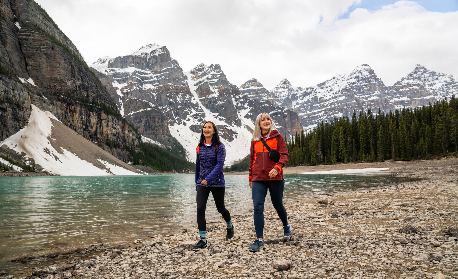 Two women walk along the Moraine Lake lakeshore in Banff National Park, the easiest hike at Moraine Lake.