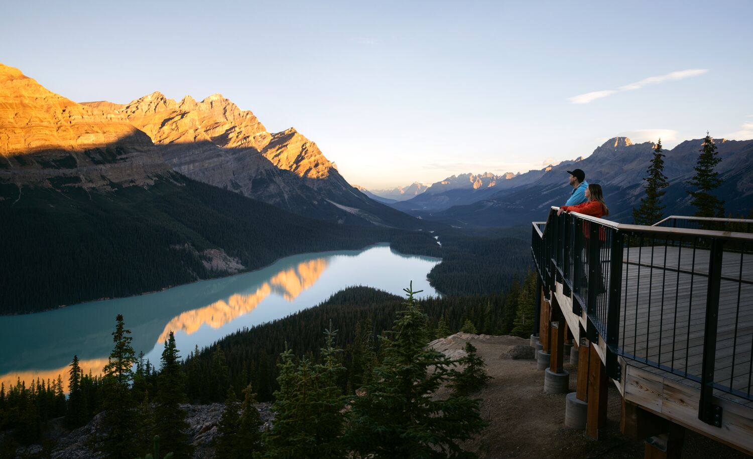 Two people stand at a viewpoint over looking Peyto Lake after hiking in Banff National Park.