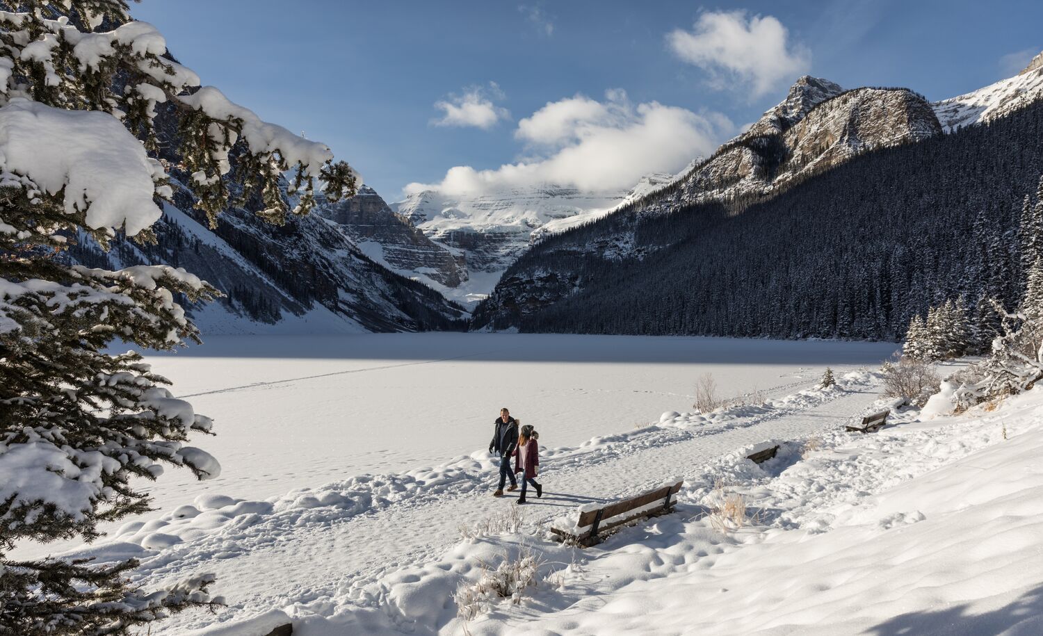 A couple walking along the Lake Louise Lakeshore trail in Banff National Park in winter