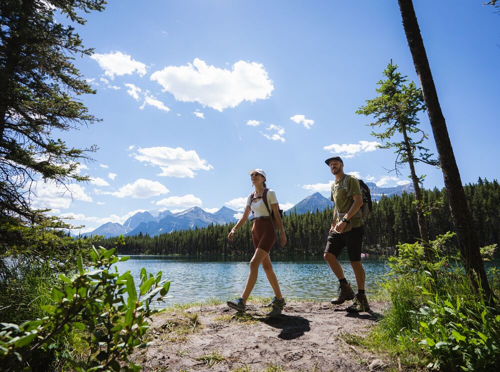 Two people hiking along a lake in Banff National Park
