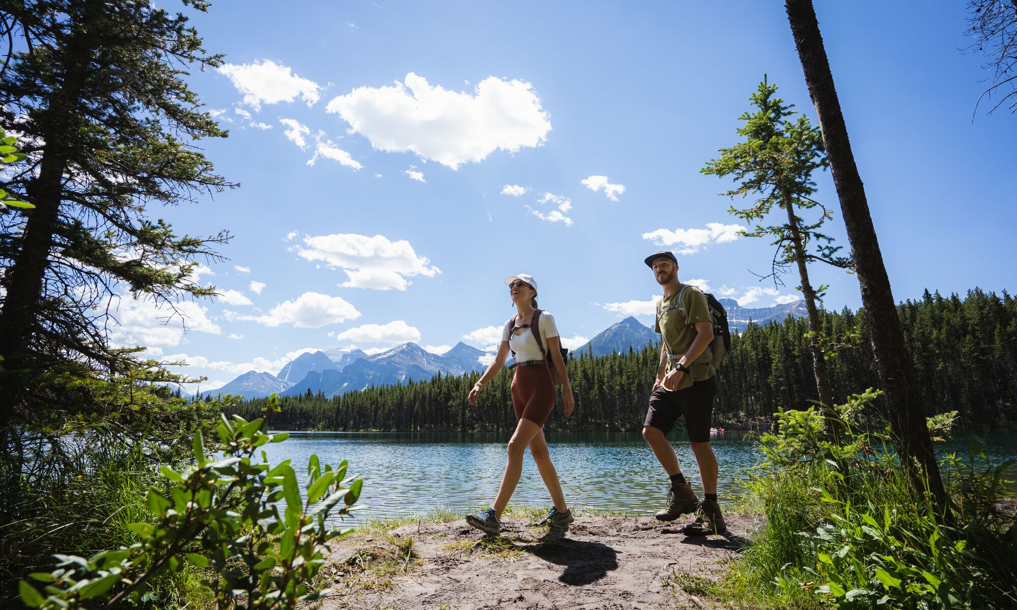 Two people hiking along a lake in Banff National Park