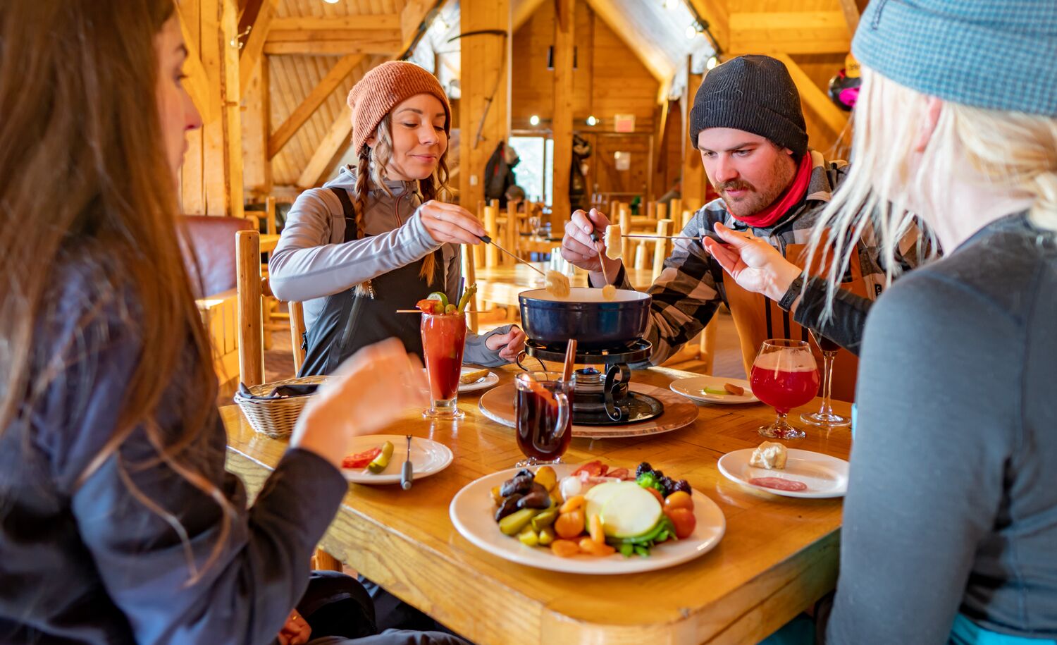 A group of friends eating fondue at the Lake Louise Ski resort in Banff National Park