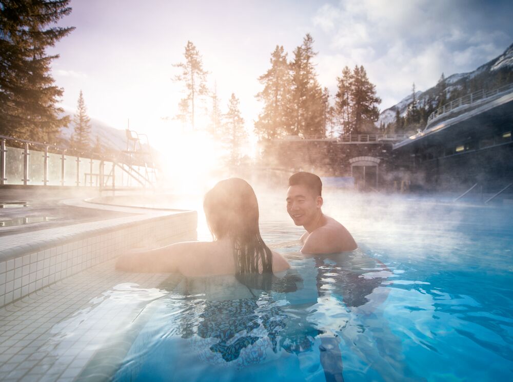 A couple inside the Banff Upper Hot Springs in the winter.