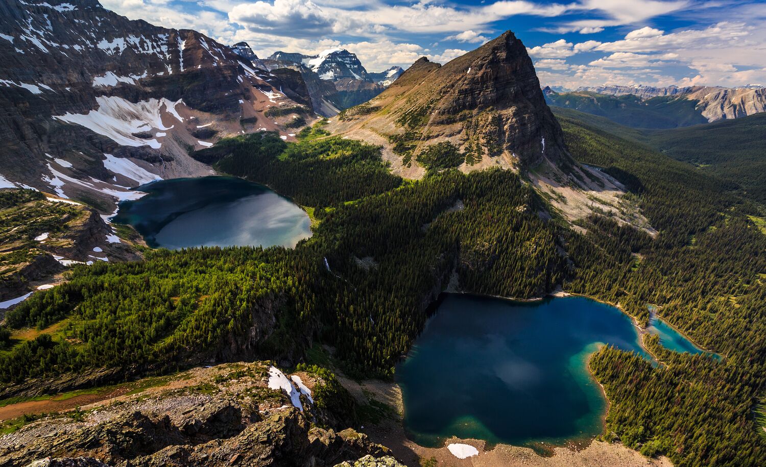 A summit-top view of two lakes and Pharaoh Peak in the Egypt Lake area in Banff National Park, one of the places you can mountain bike and then hike in Banff National Park.
