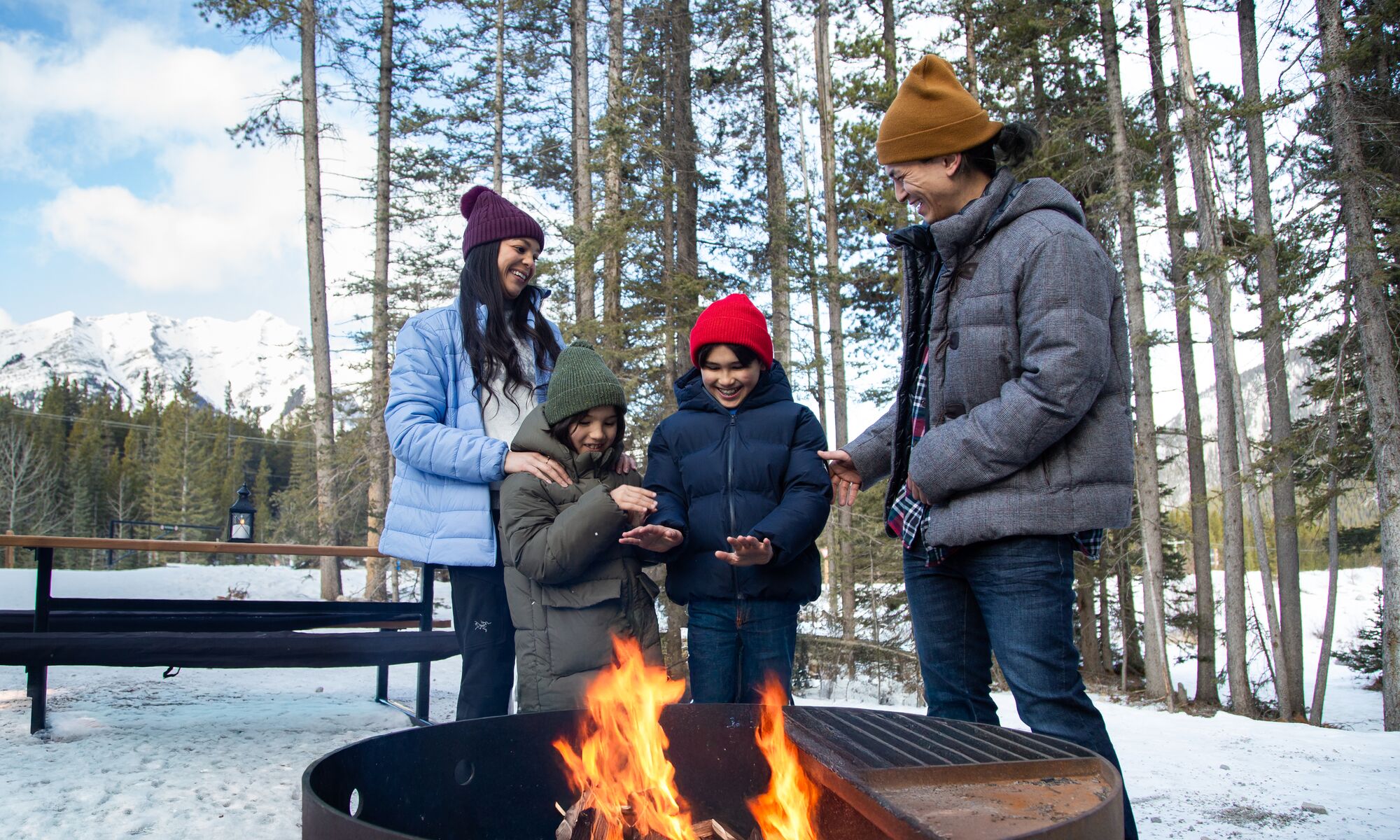 A family standing around a fire bit in the Canadian Rocky Mountians