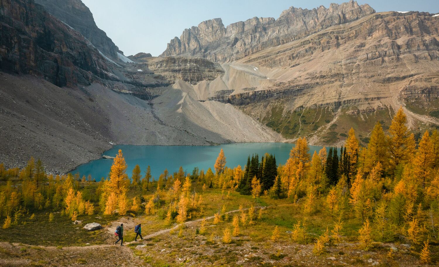 Two people hiking in Lake Louise during larch season, a popular thing to do in Banff in September