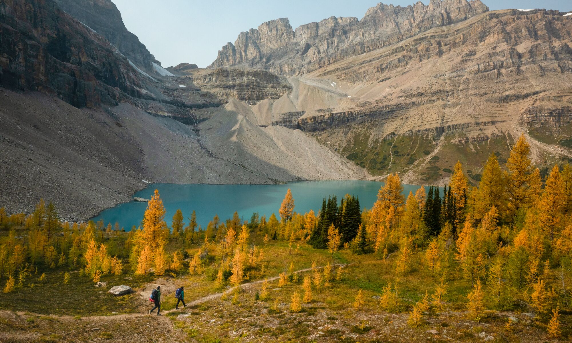 Two people hiking in Lake Louise during larch season, a popular thing to do in Banff in September