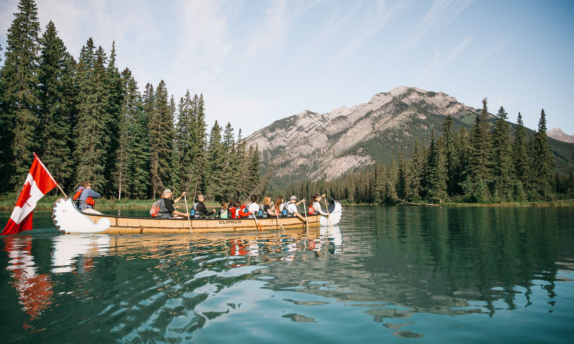 A group of people on a big canoe tour along the Bow River in Banff National Park