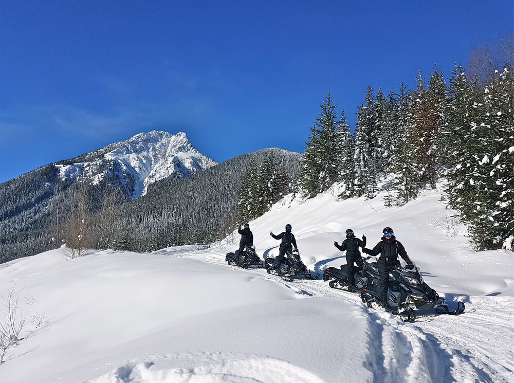 A group of people on a guided snowmobiling tour