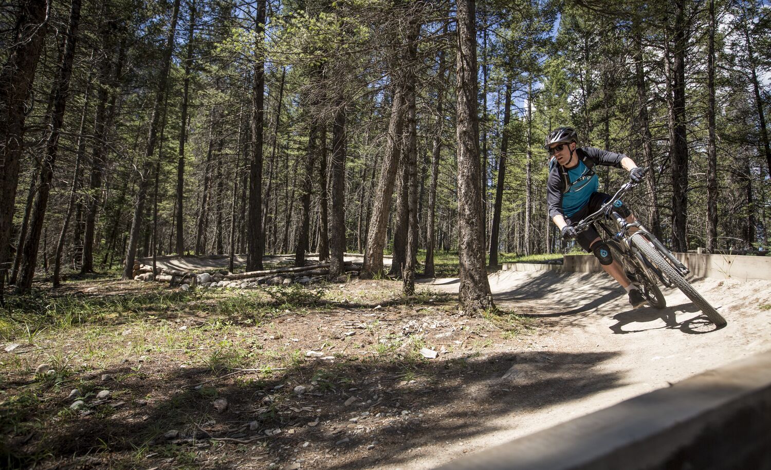 A mountain biker slides around a berm on the Tunnel Mountain Technical Trails for mountain biking in Banff.
