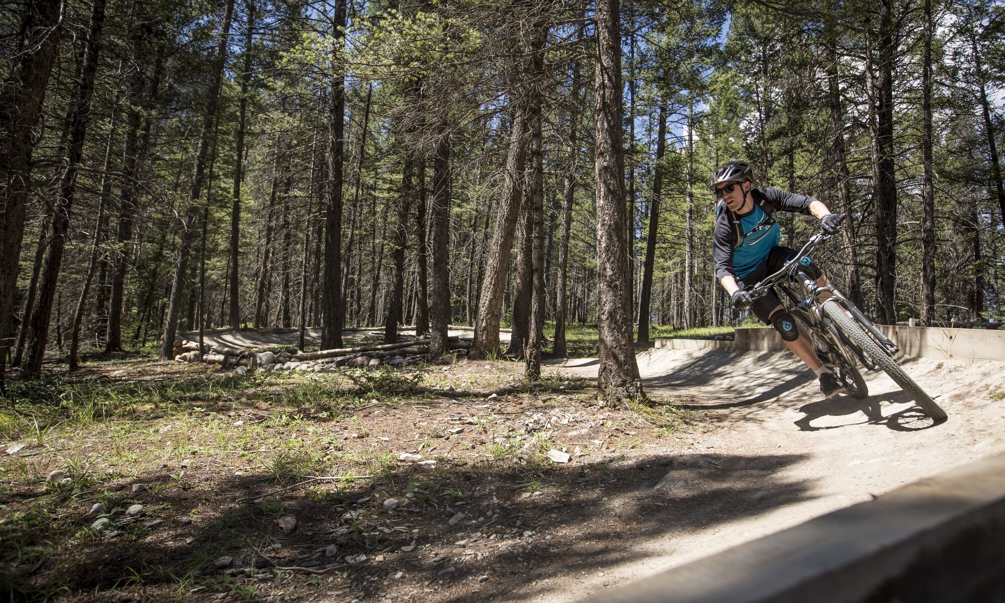 A mountain biker slides around a berm on the Tunnel Mountain Technical Trails for mountain biking in Banff.