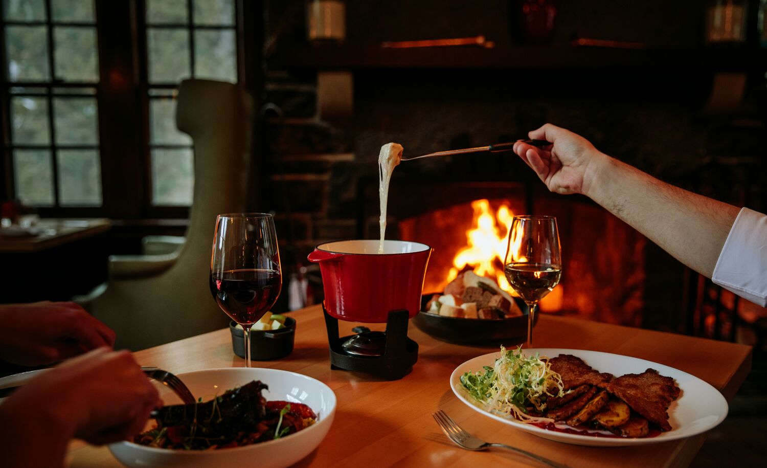 People eating fondue at the Waldhaus Pub at the Fairmont Banff Springs in Banff National Park