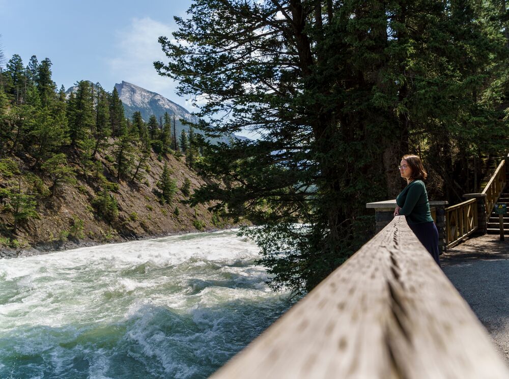 A women on the Bow River trail next to the Bow River in Banff National Park