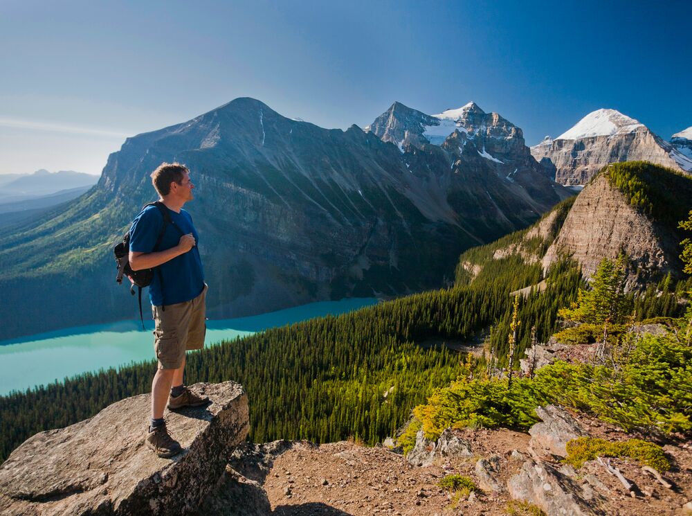 A person stands on a rock at Little Beehive in Lake Louise, one of Banff National Park's best hiking trails.