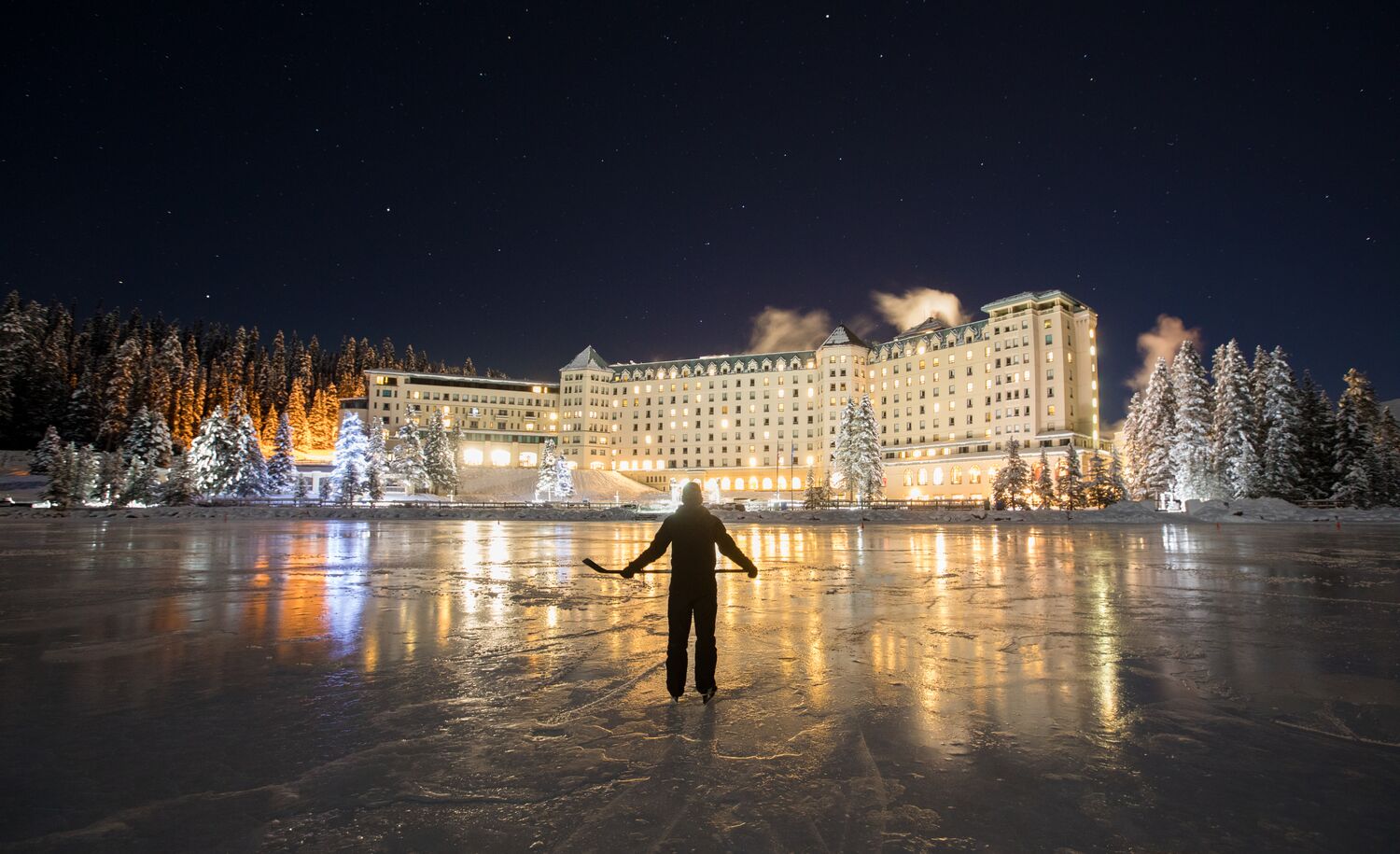 A person skating on Lake Louise at night in Banff National Park