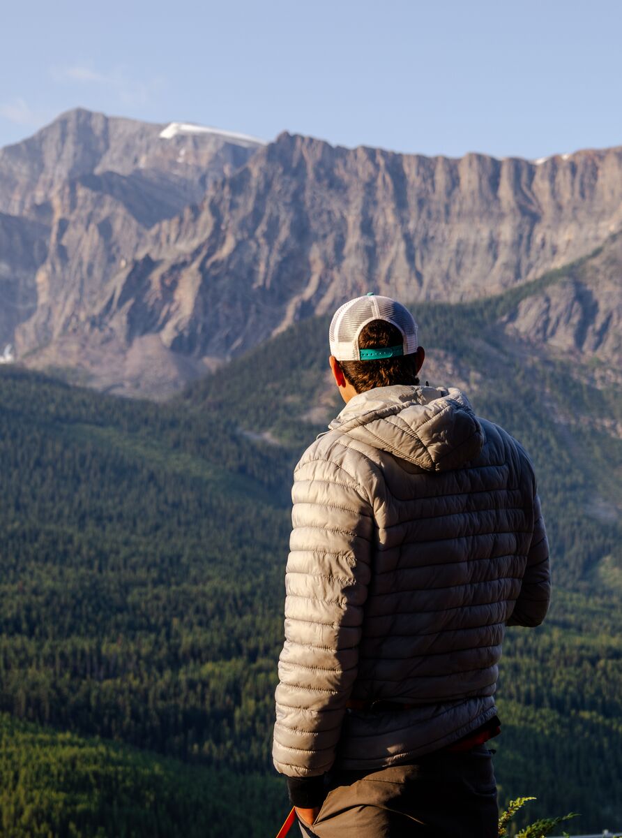 A moment of quiet reflection in the Canadian Rockies, where breathtaking mountain vistas and endless forest landscapes inspire adventure and connection with nature.