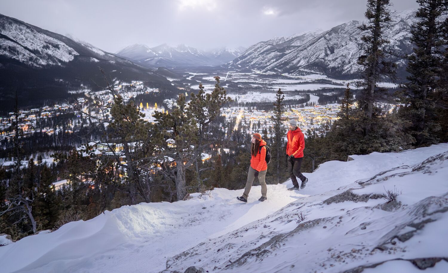 Two people hiking at blue hour on Tunnel Mountain in Banff National Park.
