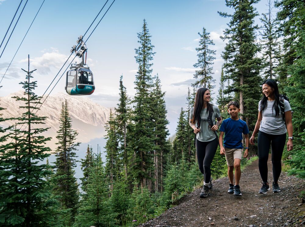 Two women and a child hike on the trail up Sulphur Mountain in Banff National Park.