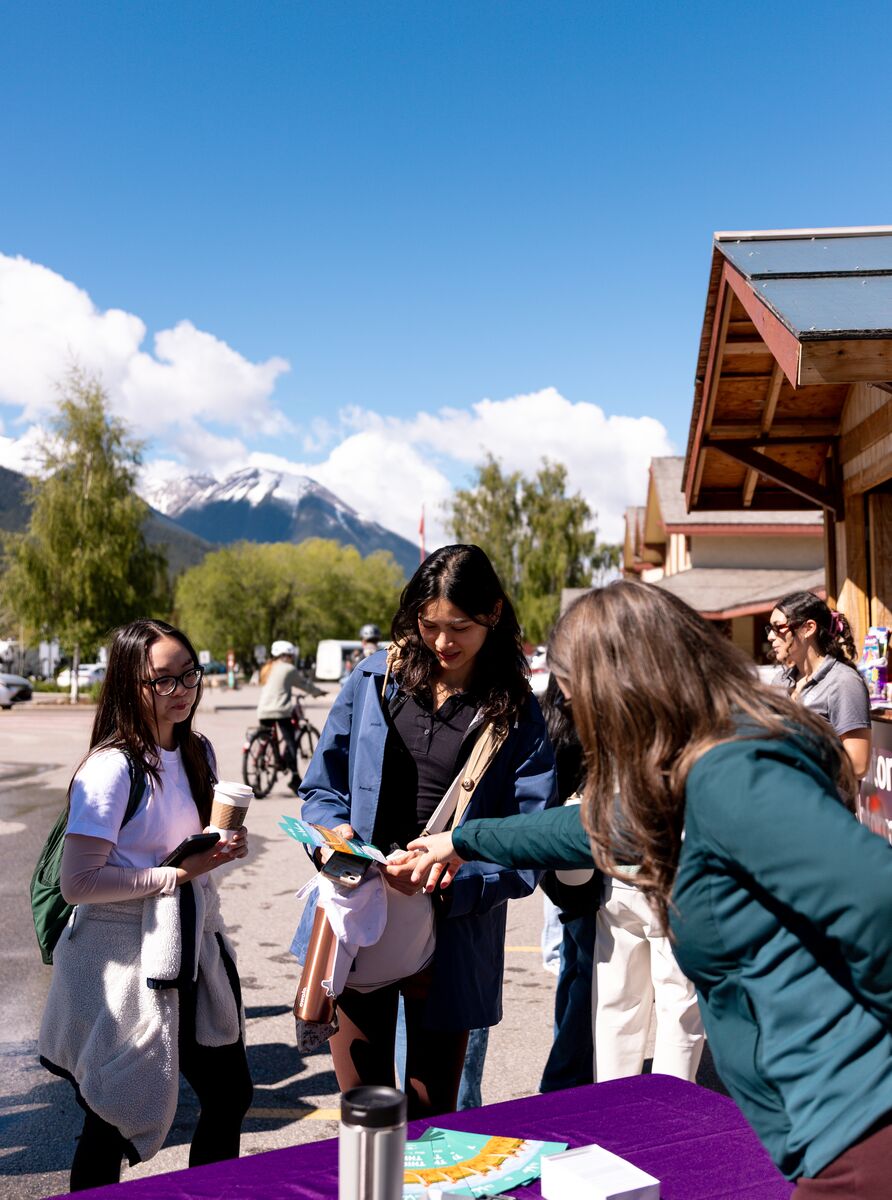 Visitors learn about Park Mode and responsible travel at an activation event outside the Banff Train Station in Banff National Park.