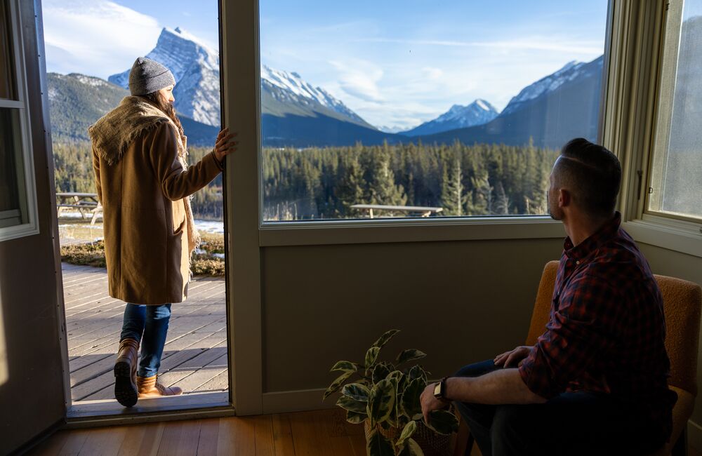 A woman looks out from her room over Banff National Park