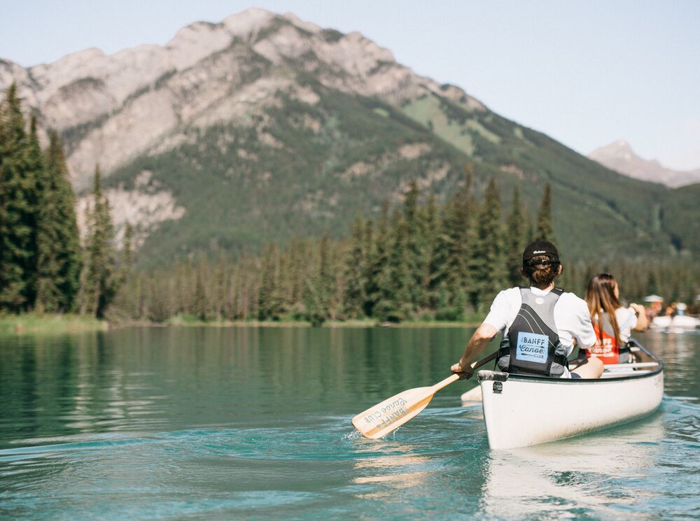 Two people canoeing on the Bow River in Banff National Park, a popular thing to do in August in Banff