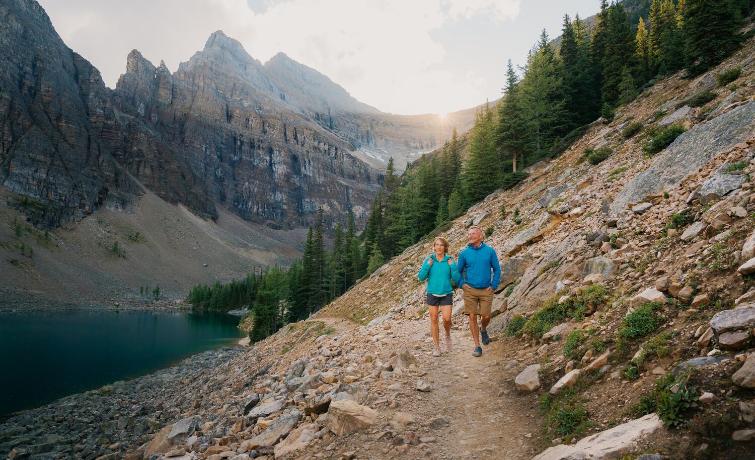 Two people hiking in Banff National Park in Lake Louise on the Lake Louise Tea House Trail to Lake Agnes.