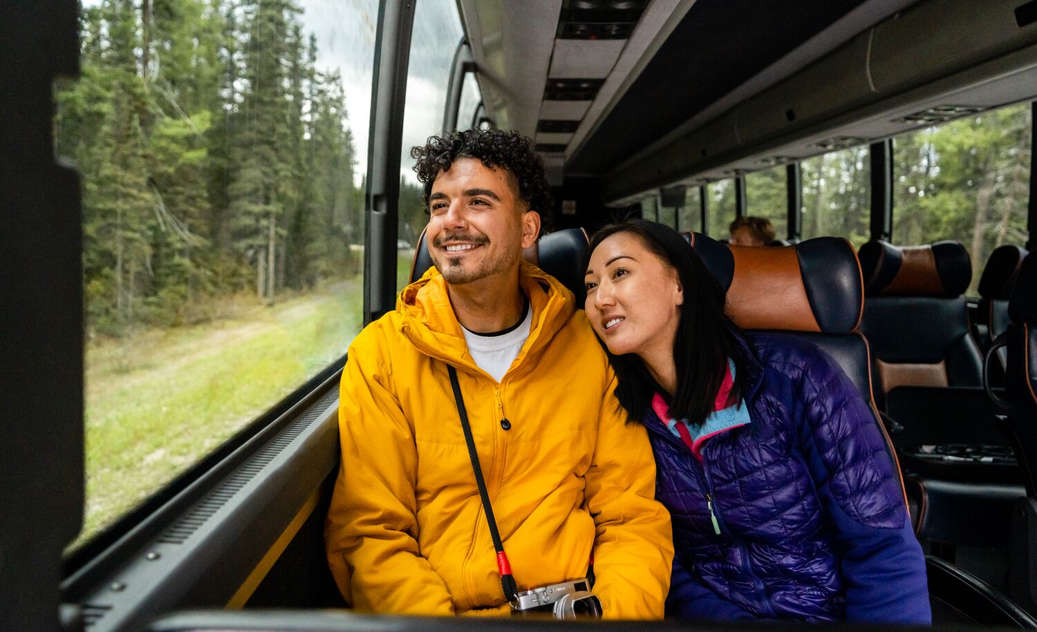 Two people sitting on a shuttle bus to Moraine Lake in Banff National Park
