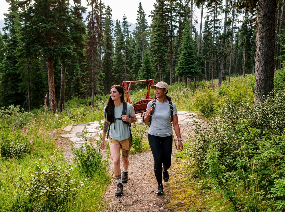 Two people hiking in the woods in Banff National Park