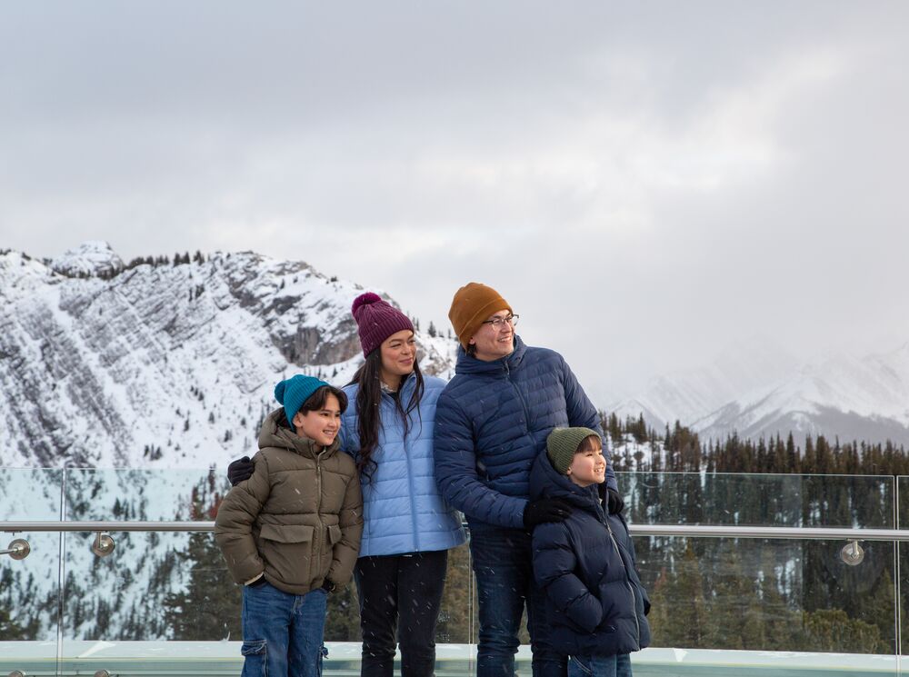 A family of four on top of the Banff Gondola in winter in Banff National Park