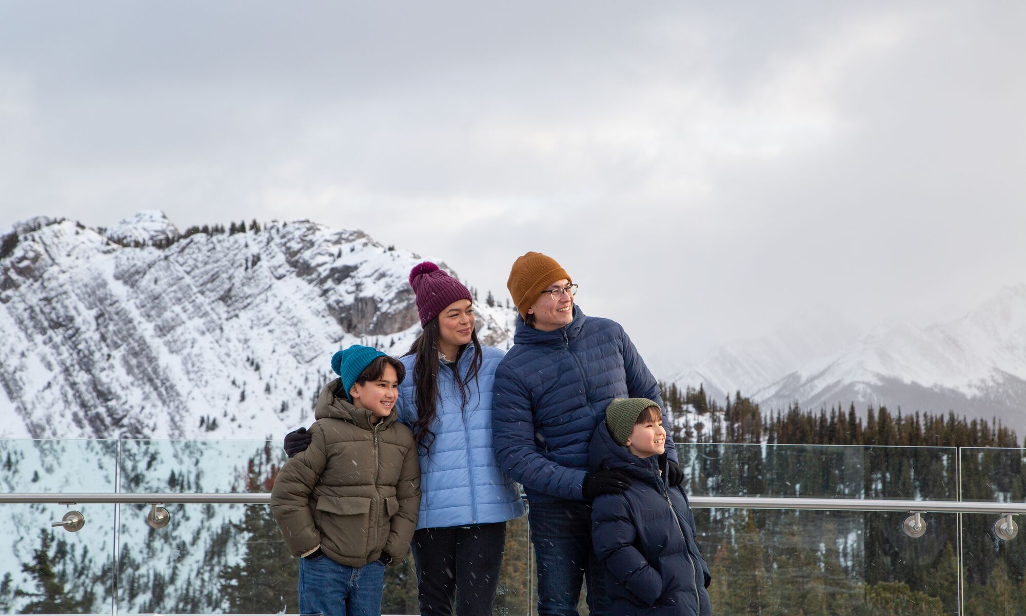 A family of four on top of the Banff Gondola in winter in Banff National Park