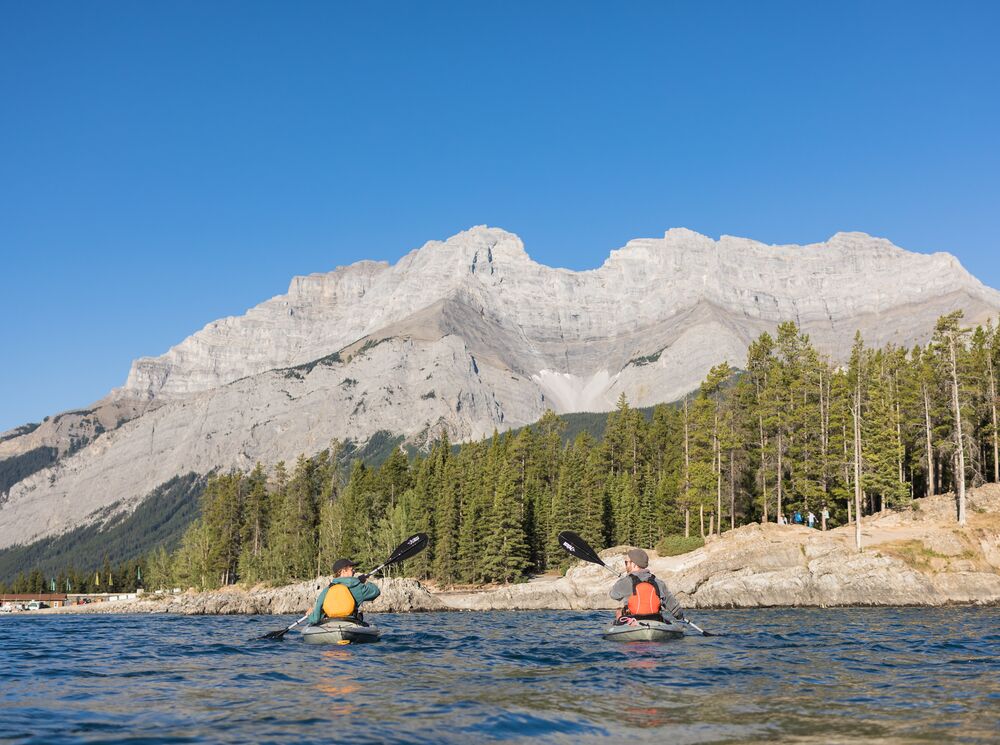 Two people kayaking on Lake Minnewanka in Banff National Park