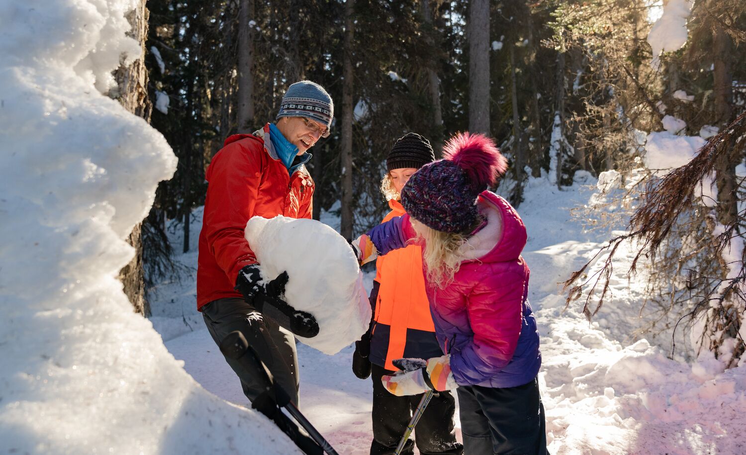 People look at a snow pack on a guided hiking tour in Banff National Park.