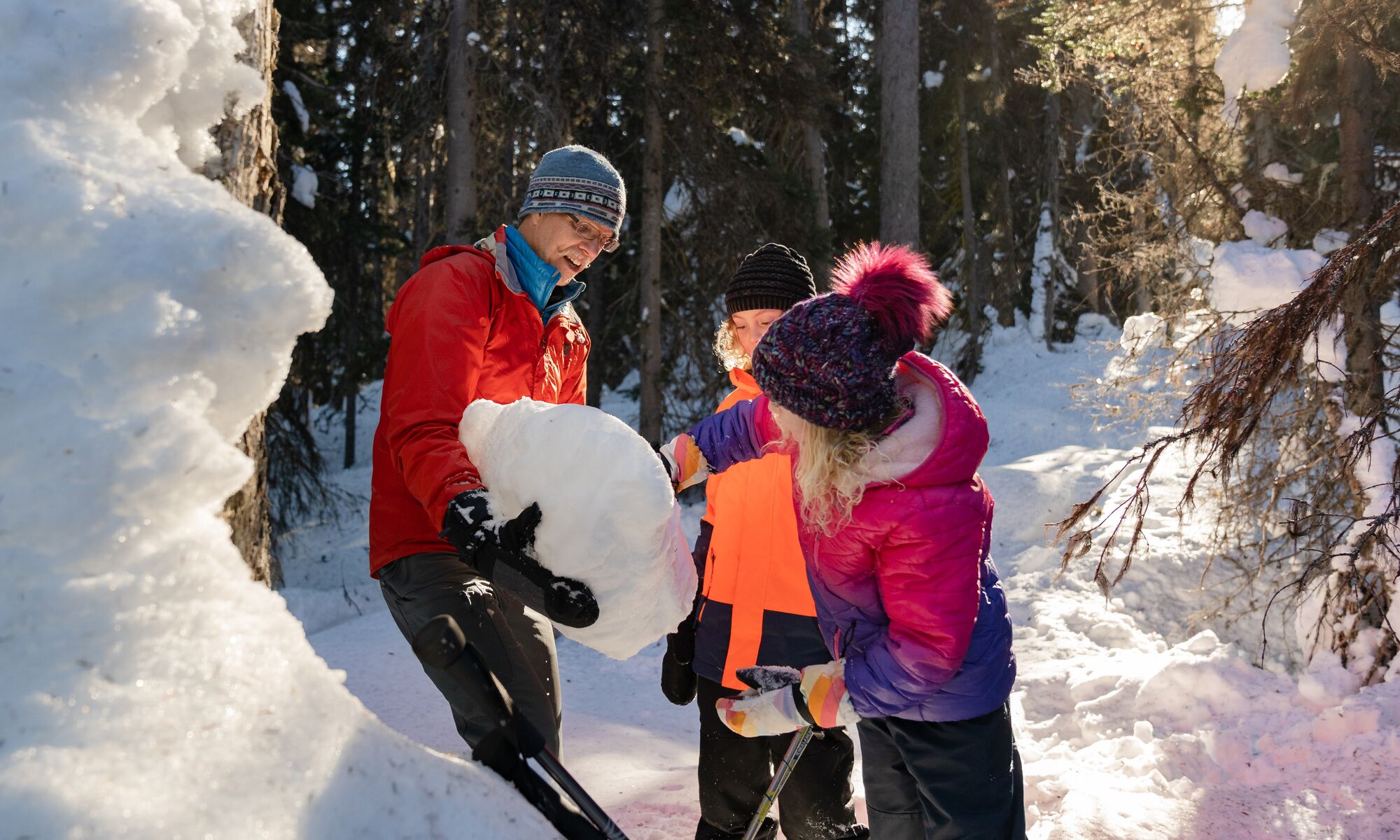 People look at a snow pack on a guided hiking tour in Banff National Park.
