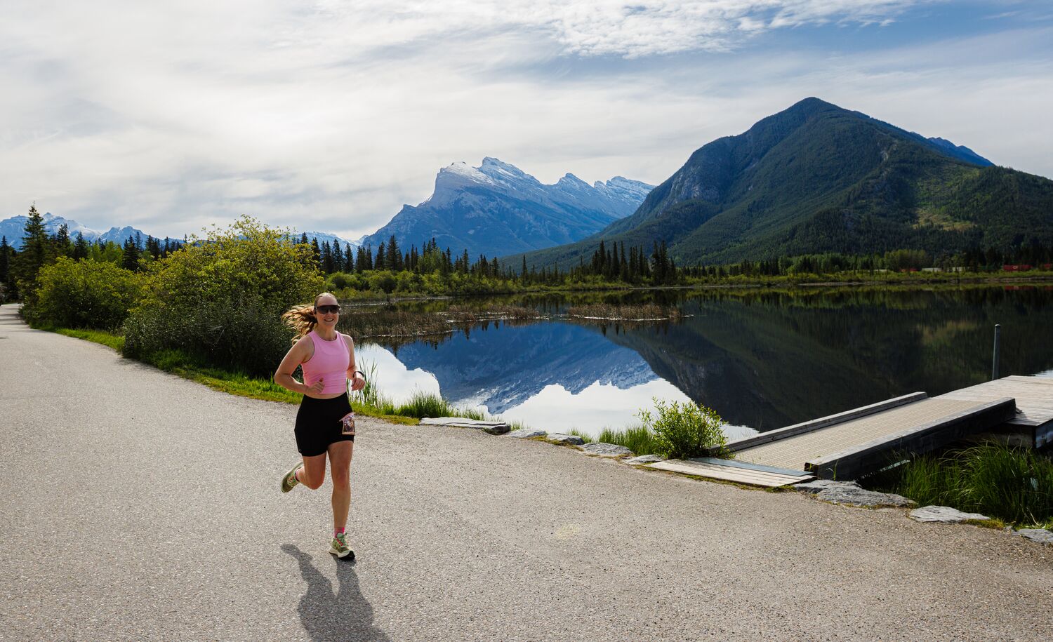 Woman running along the scenic Vermilion Lakes route during the Banff Half Marathon in Banff National Park, surrounded by mountain views and pristine wilderness at one of Canada's most iconic destination races for runners of all levels.