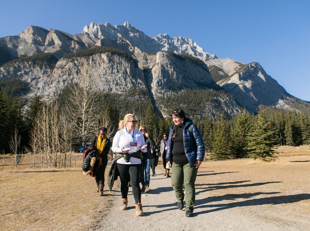 People participate in a Medicine Walk at Cascade Ponds with Cascade Mountain in the background.