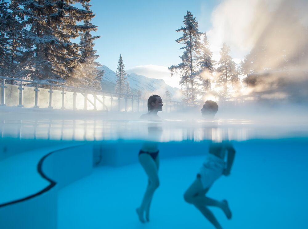 A couple swims in the Banff Upper Hot Springs in Banff, Canada.