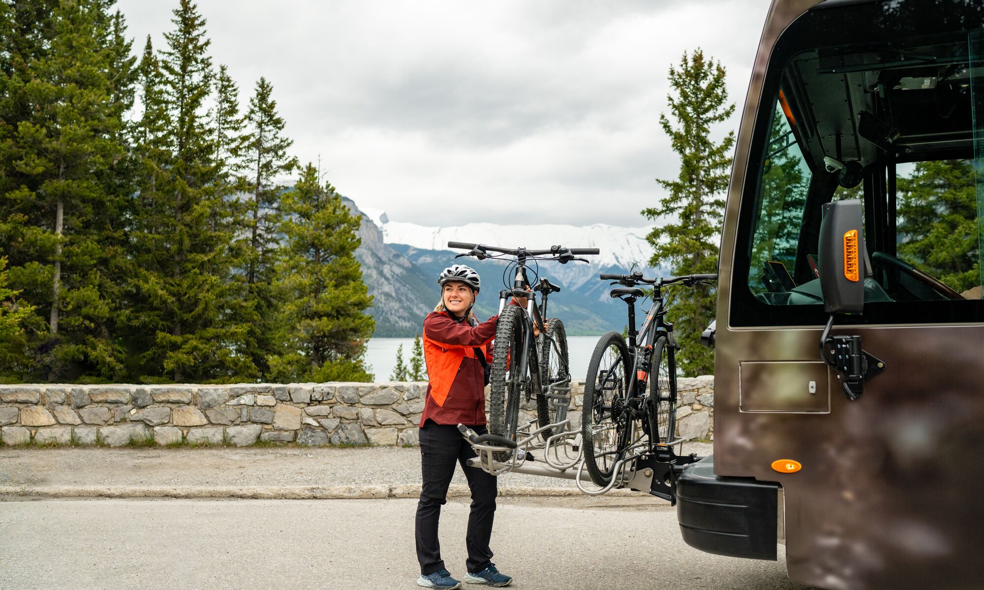 A Roam Transit bus stops along the Minnewanka Loop in Banff National Park as a passenger unloads her bike