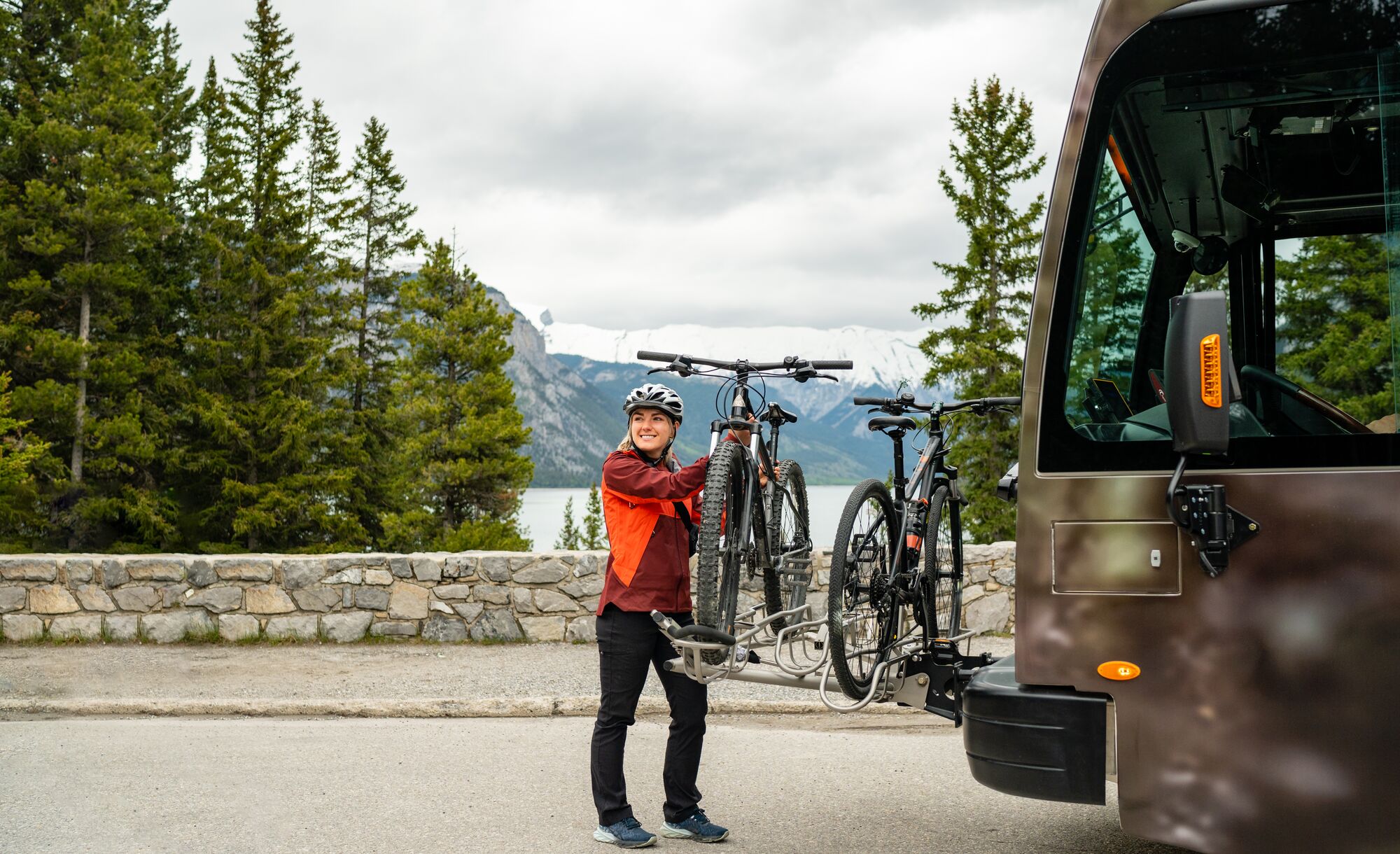 A Roam Transit bus stops along the Minnewanka Loop in Banff National Park as a passenger unloads her bike