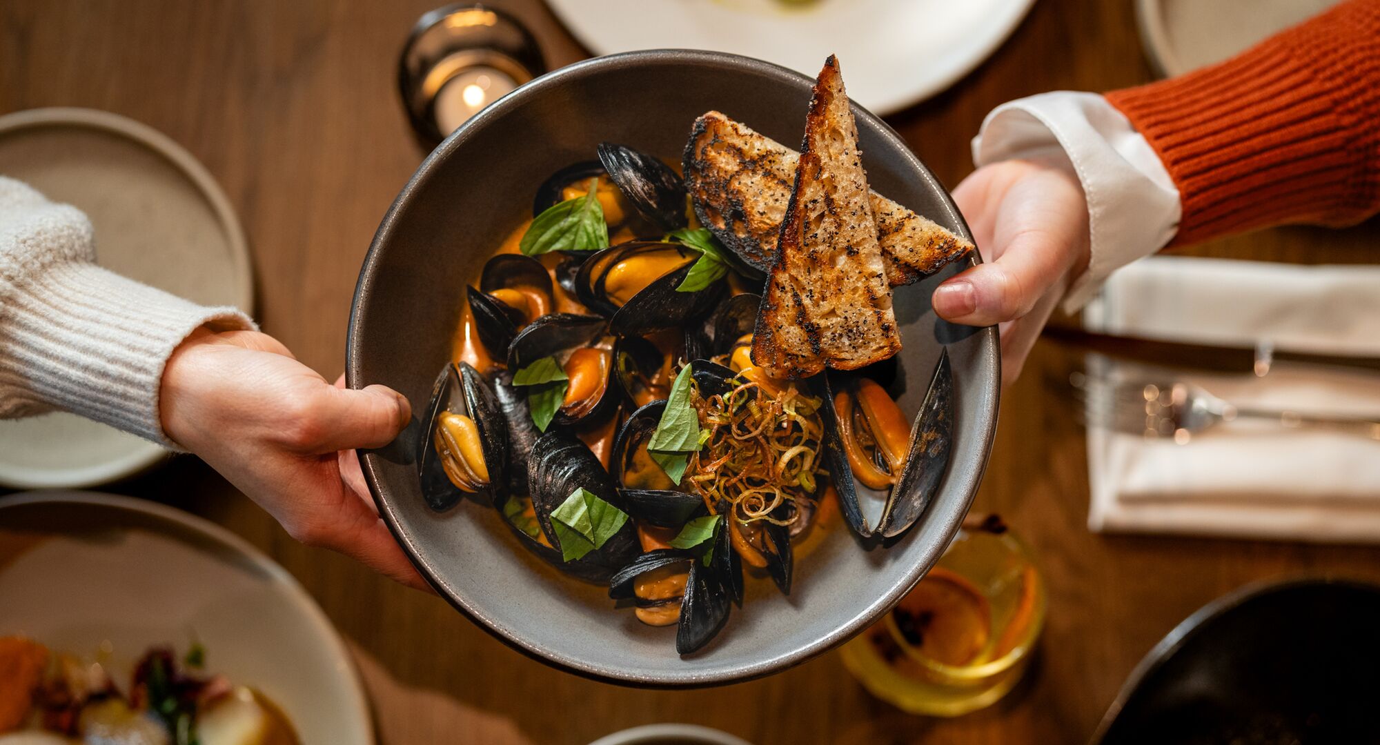 Thai basil Mussels served in a lush red curry broth, paired with locally sourced grilled sourdough