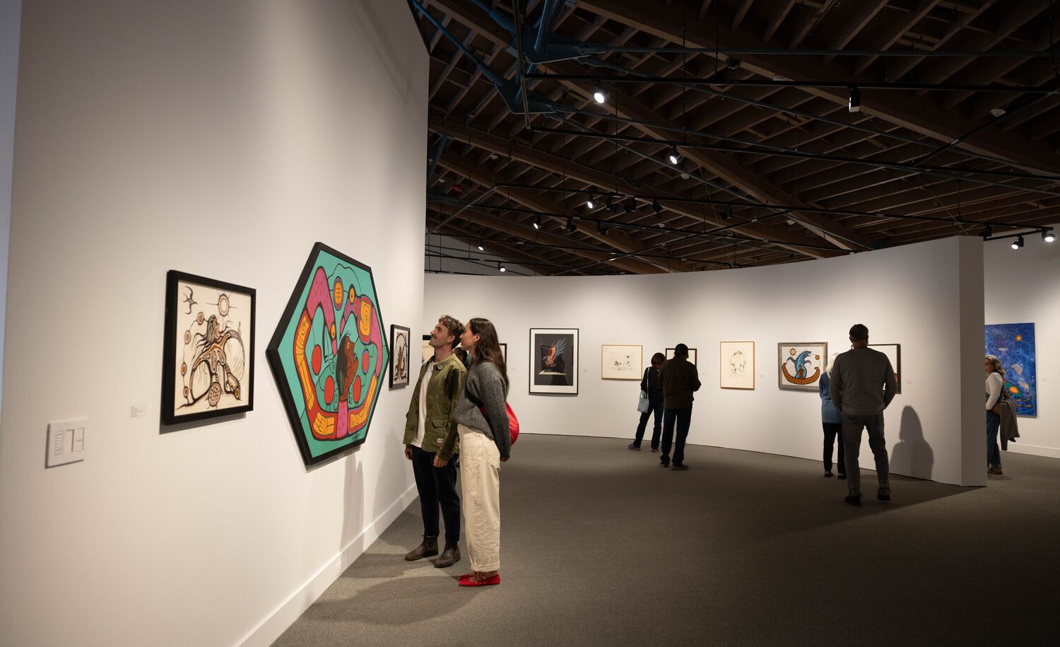Two people looking at art at the Whyte Museum of the Canadian Rockies.