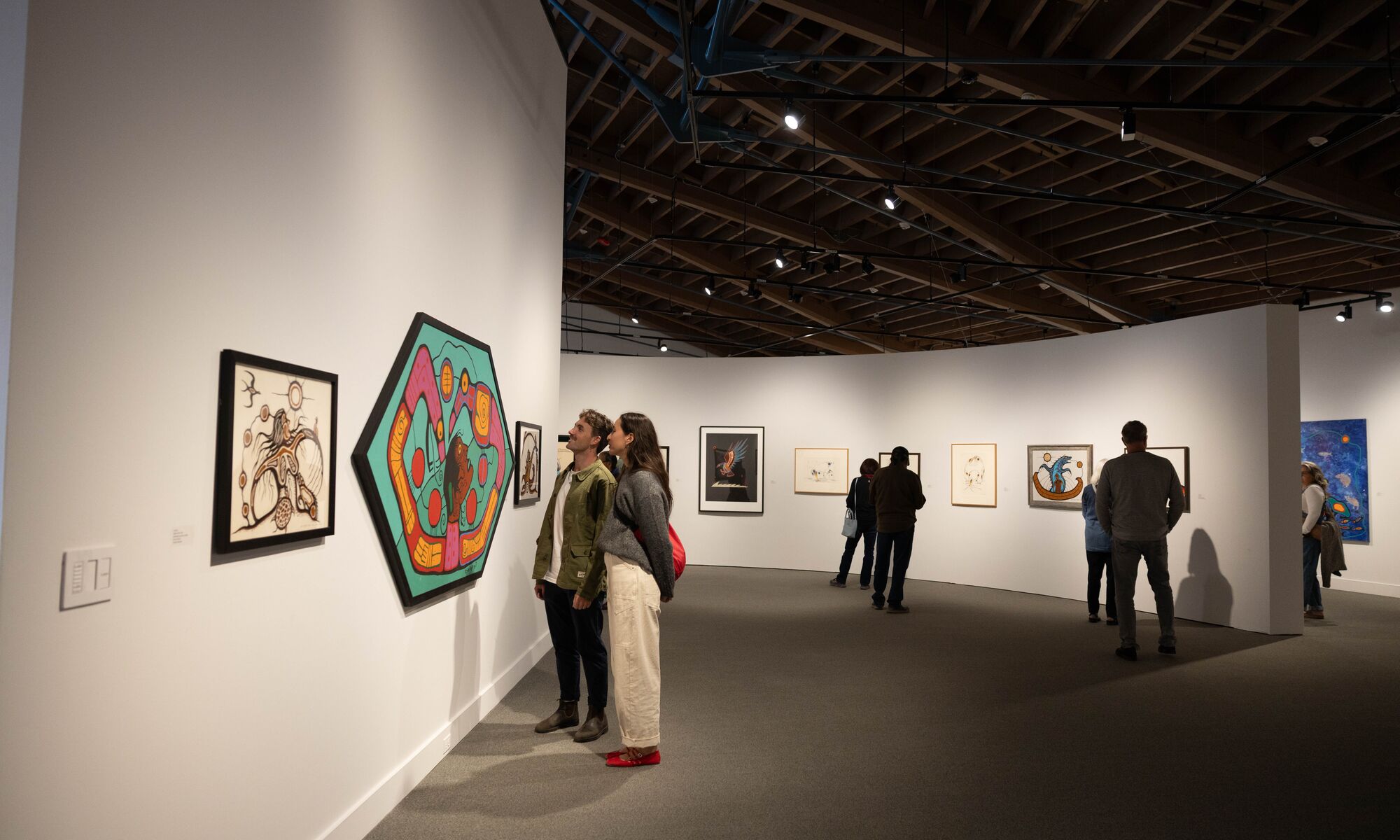 Two people looking at art at the Whyte Museum of the Canadian Rockies.
