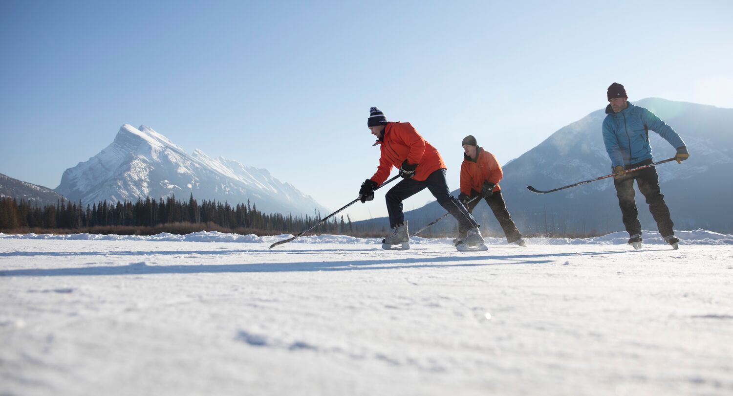 Friends playing ice hockey on Vermillion Lakes in Banff National Park