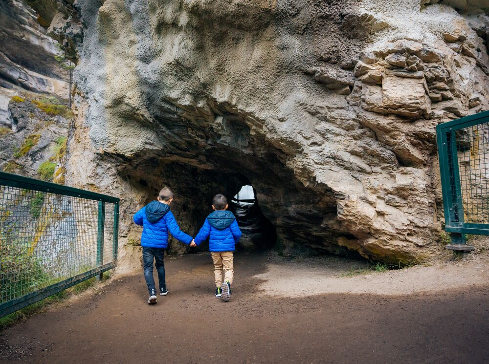 Two boys run into the Lower Falls at Johnstons Canyon in Banff National Park.