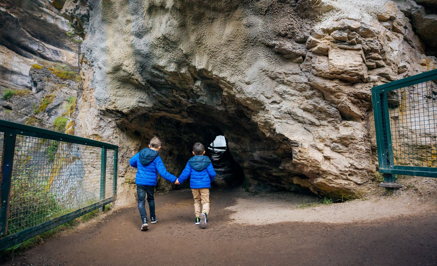 Two boys run into the Lower Falls at Johnstons Canyon in Banff National Park.