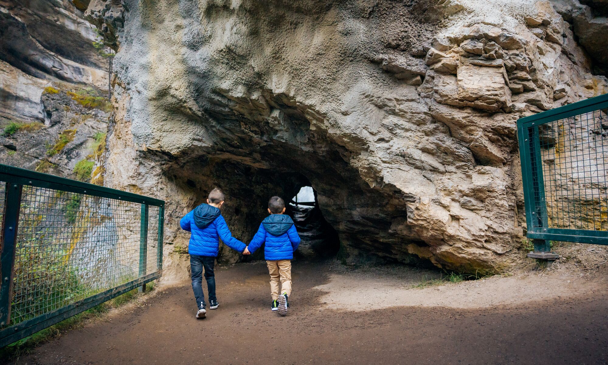 Two boys run into the Lower Falls at Johnstons Canyon in Banff National Park.