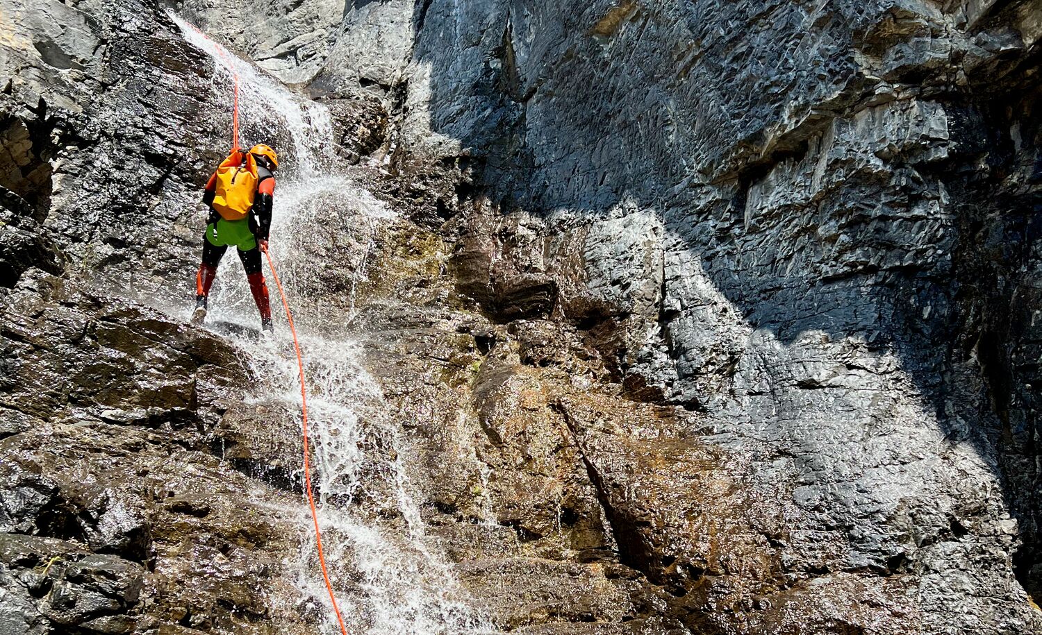 A person repelling down a waterfall in a canyon with Bow Valley Canyon Tours