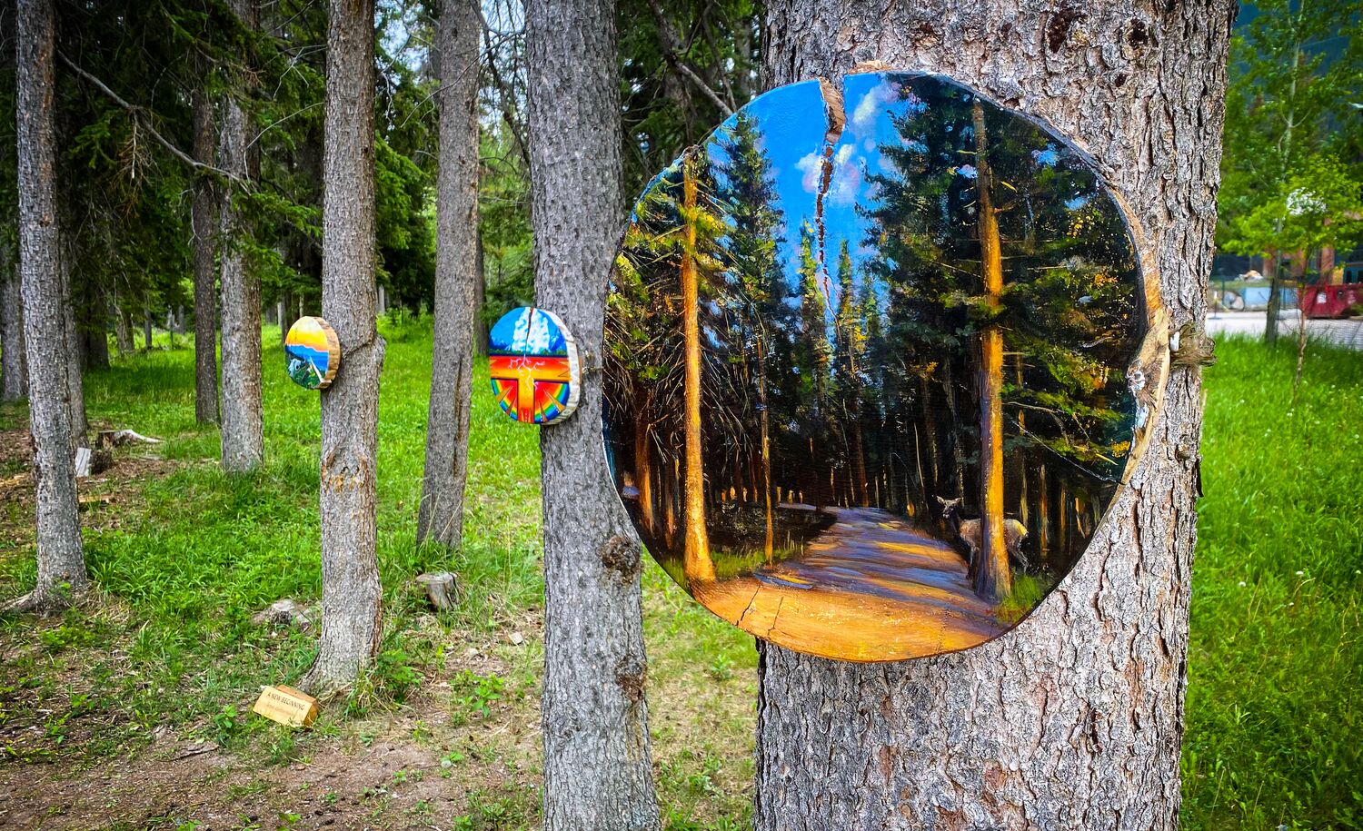 Paintings hang on trees during the Art in Nature Trail in Banff.