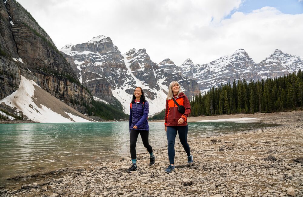 Two friends explore the Moraine Lake lakeshore in Banff National Park