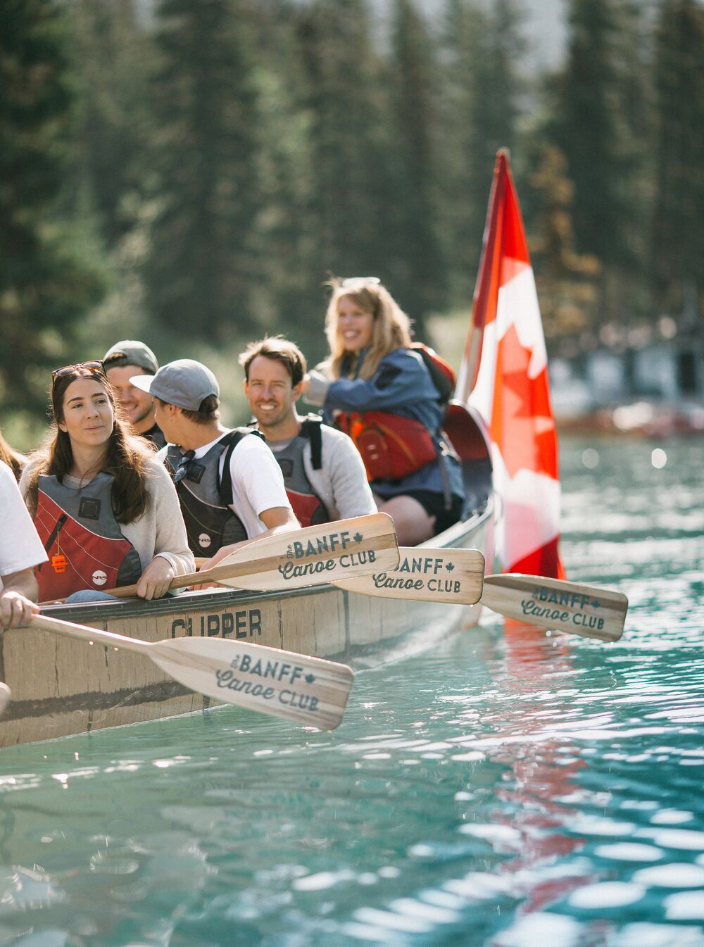 People in an old wooden canoe from Banff Canoe Club on the Bow River in Banff.